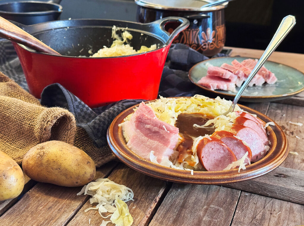 Ouderwetse zuurkoolstamppot met zuurkoolspek, rookworst en gebonden jus, geserveerd op een bord