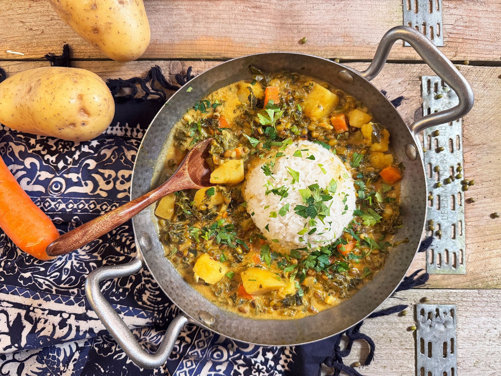 Bord met romige mungbonen curry en boerenkool, geserveerd met rijst