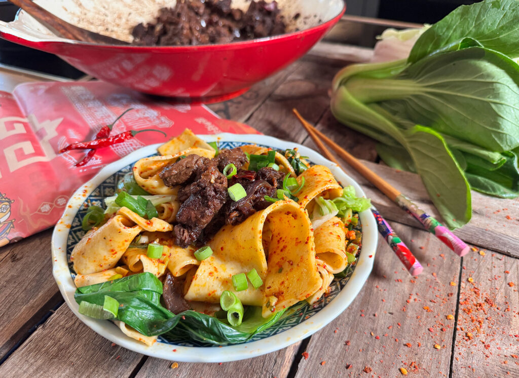 Zelfgemaakte Bjang Bjang noodles in een bowl met groenten, vlees en chili-olie
