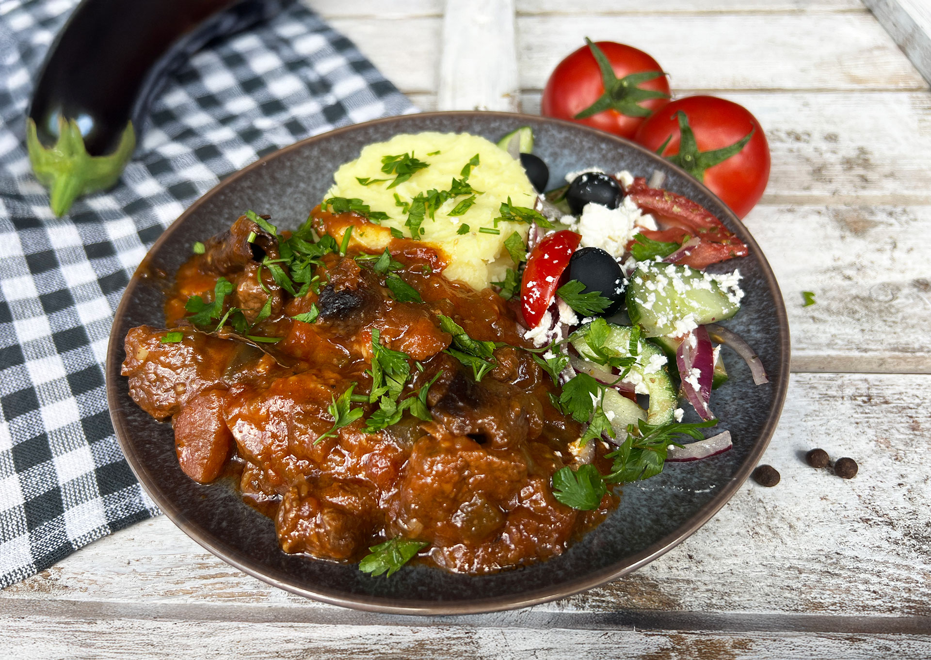 Stifado met rundvlees geserveerd met aardappelpuree en Griekse salade