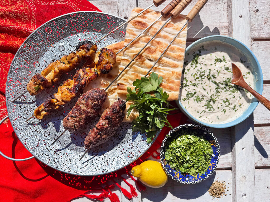 Streetfood-stijl opgemaakt bord met kabobs, saus en flatbread