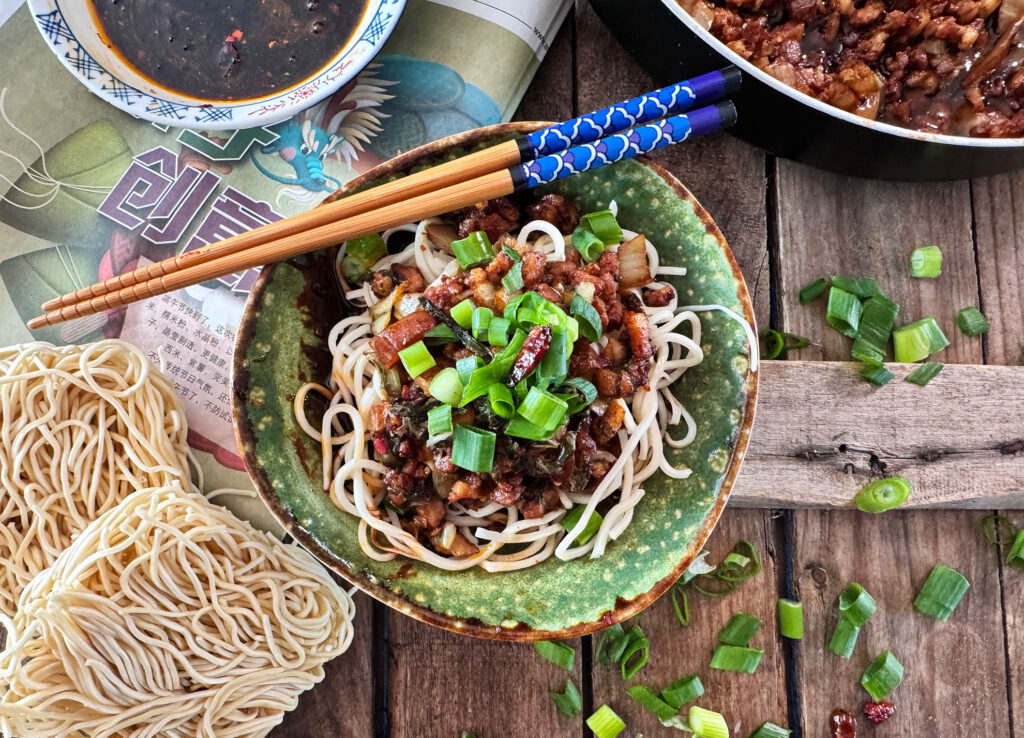 Dan Dan Noodles in een kom met gehakt, bosui en pittige chili-olie