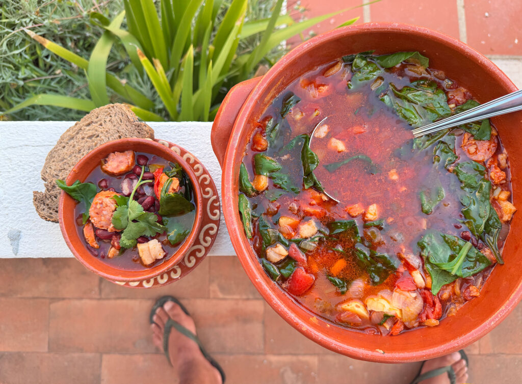 Portugese bonensoep (sopa de feijão) geserveerd in een kom met chorizo en spek