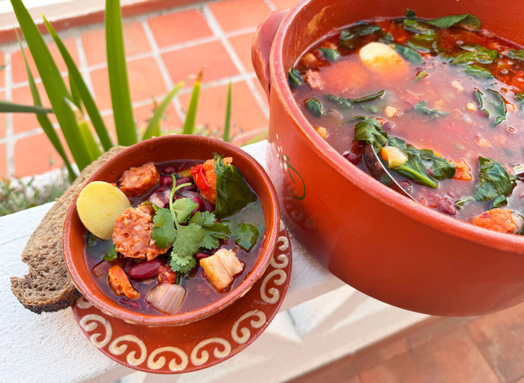 Portugese bonensoep (sopa de feijão) geserveerd in een kom met chorizo en spek