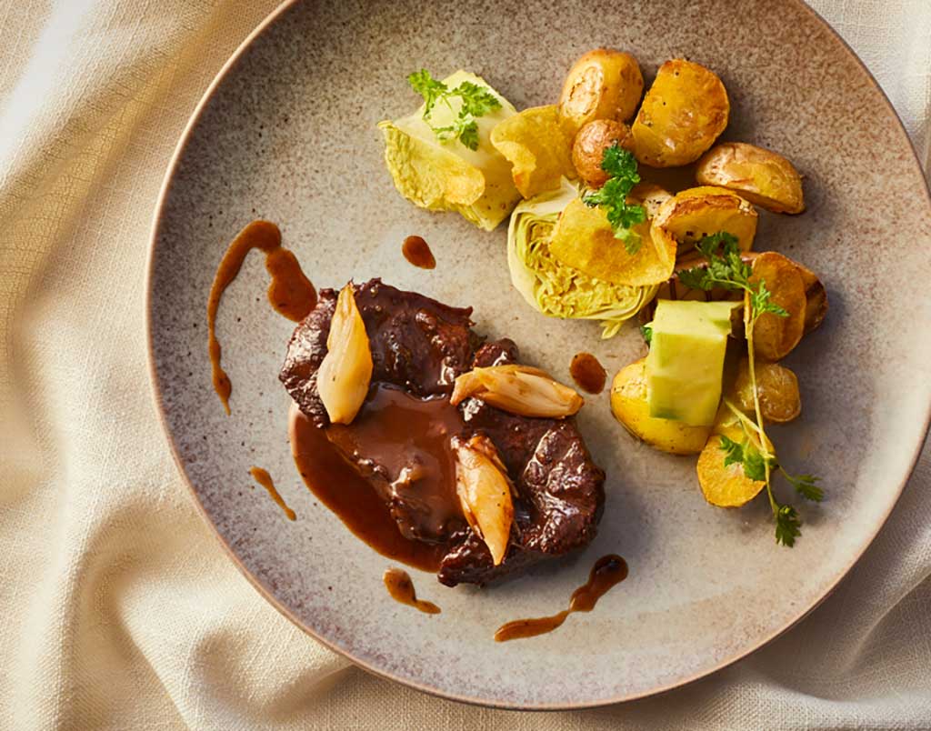 Zacht gegaarde sukade met rode wijnsaus, krieltjes en truffelspitskool