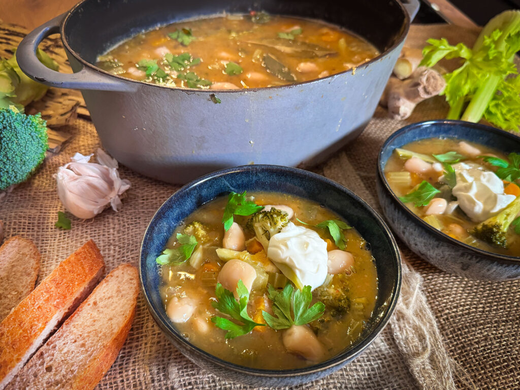Vegetarische Toscaanse witte bonenstoof met pompoen, broccoli en witte bonen in stoofpan en een kom