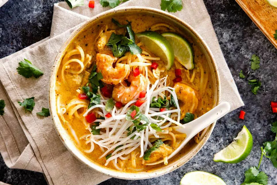 Kom met romige laksa soep met kokosmelk, noedels en koriander