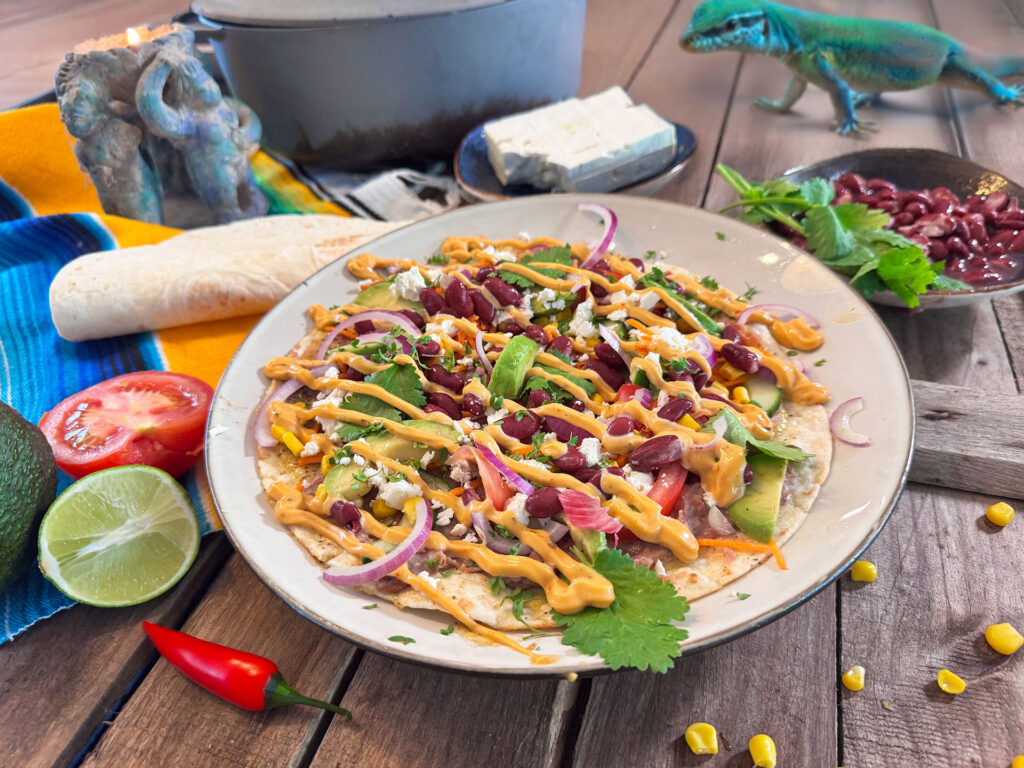 Mexicaanse tortilla omelet met ei, bonen, avocado, tomaat en groenten op een bord.