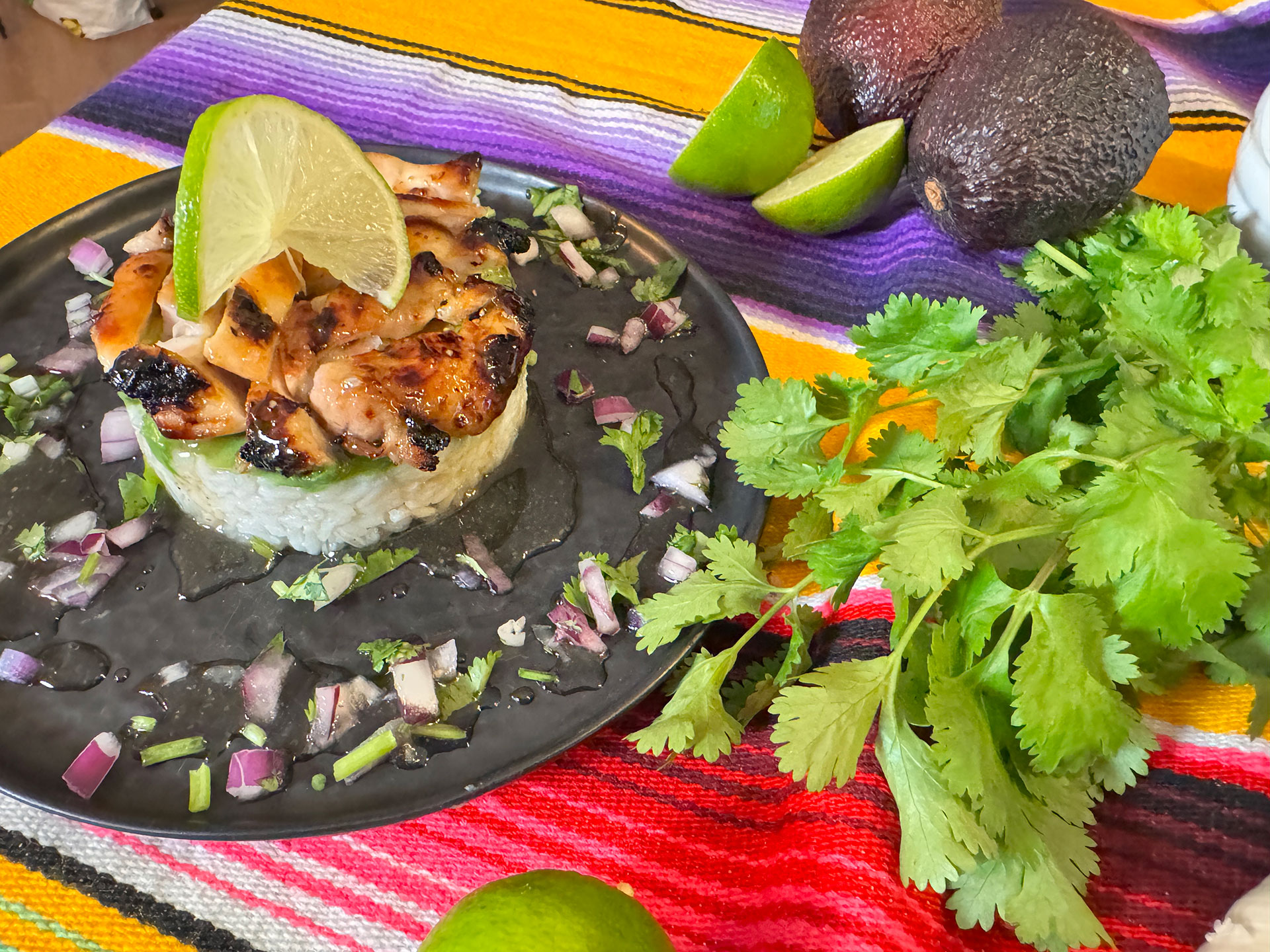 Opgebouwde rijsttoren met avocado en gegrilde kip.