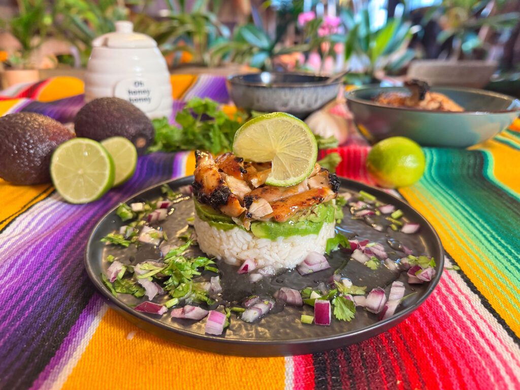Mexican rice avocado stack met honey lime chicken en limoen.