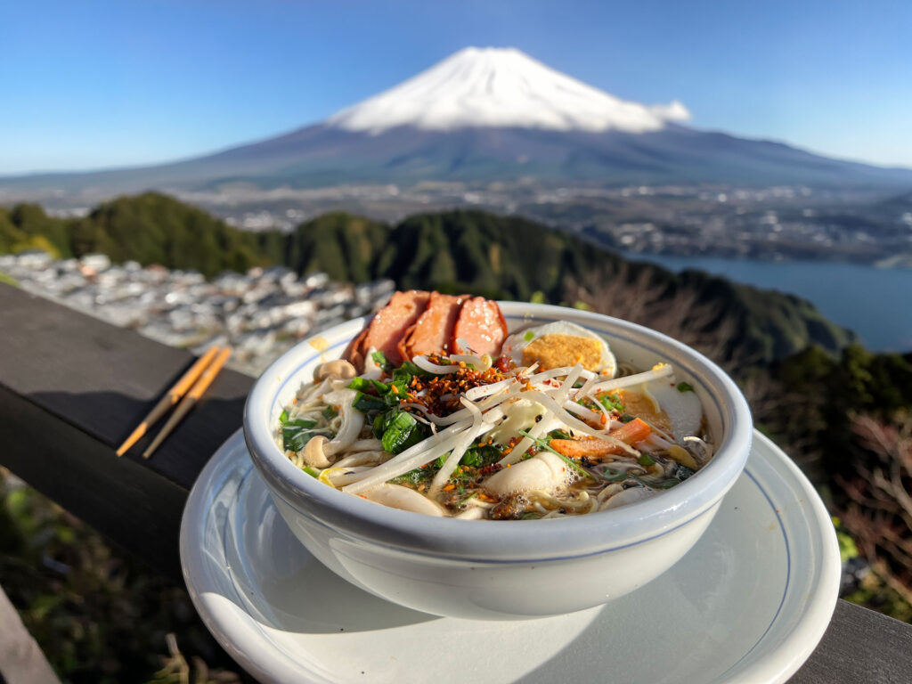 Instant noodle soup met verse toppings en Mount Fuji op de achtergrond