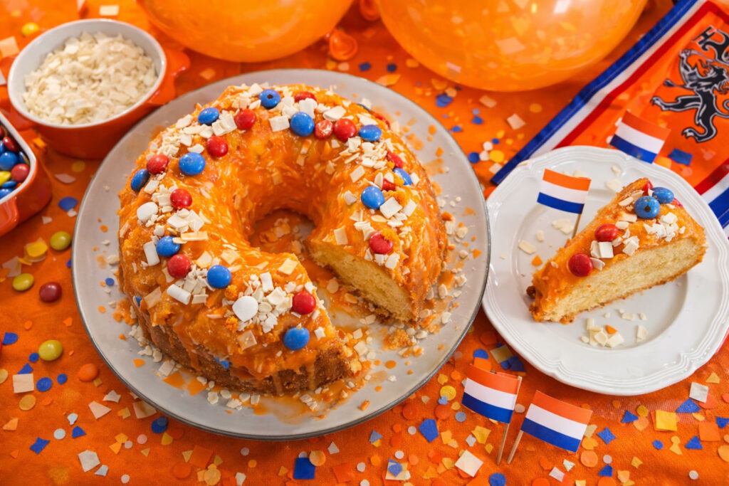 Oranje sinaasappelcake met glazuur en feestelijke topping voor Koningsdag.