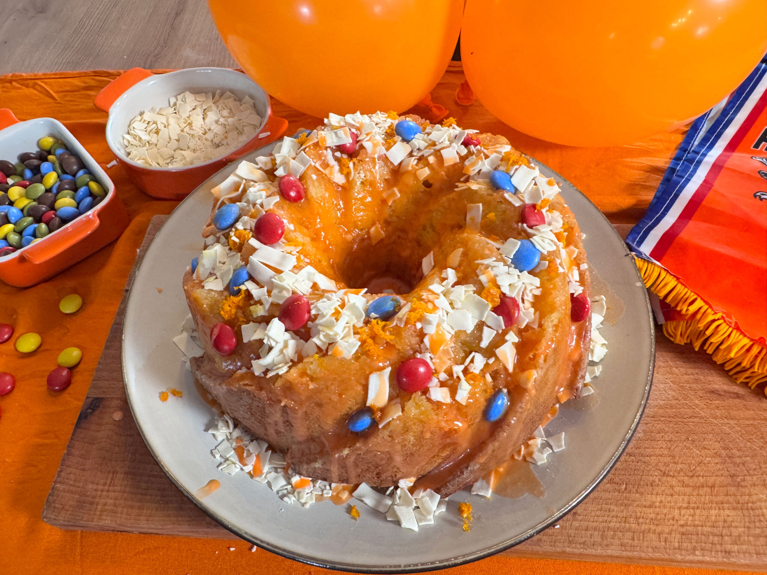 Oranje sinaasappelcake met glazuur en feestelijke topping voor Koningsdag.