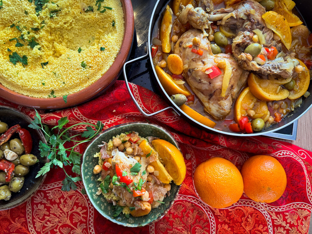 Marokkaanse kip tajine met sinaasappel, abrikozen, kikkererwten en olijven geserveerd met couscous.
