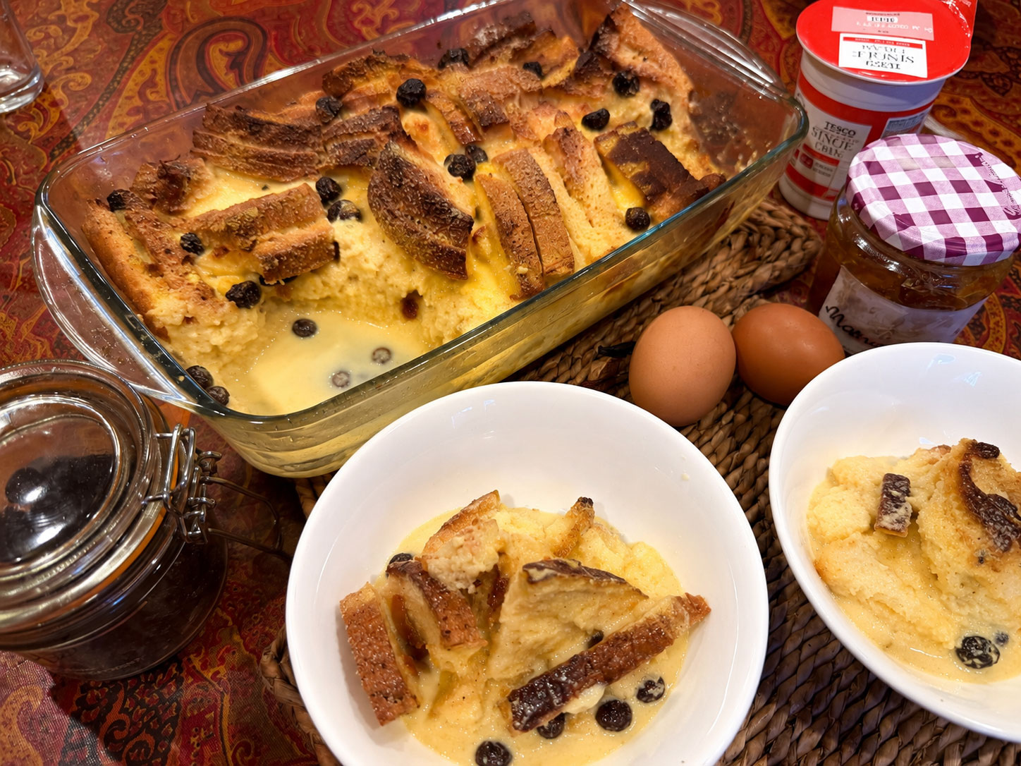 Traditionele Britse Bread and Butter Pudding met romige custard en rozijnen in een ovenschaal.