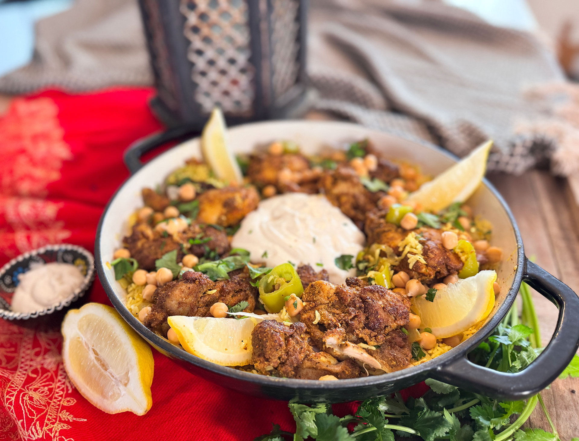 Chicken Mandi met gekruide kip, basmatirijst, kikkererwten, groene puntpaprika, koriander en knoflook-yoghurtsaus.