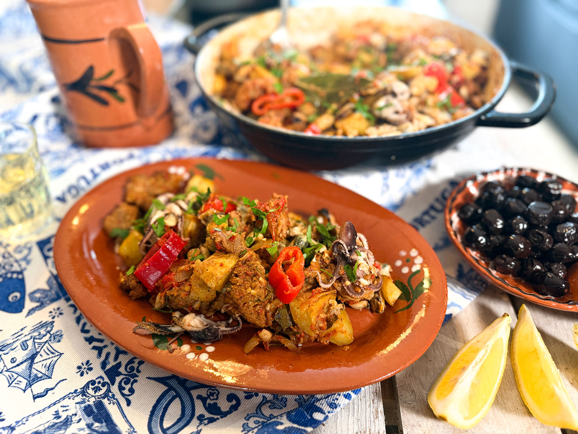 Portugese Surf & Turf met mals varkensvlees, garnalen, mosselvlees, inktvis en geroosterde aardappeltjes in een rijke paprikasaus.
